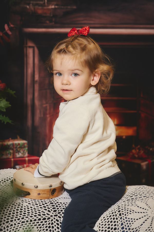 Petite fille qui joue d'un tambourin posé sur un pouf au crochet, décor de Noël chez Aubert à Coudekerque-Branche