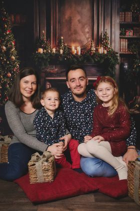 Famille de quatre assise devant une cheminée de Noël, chez Aubert à Arras