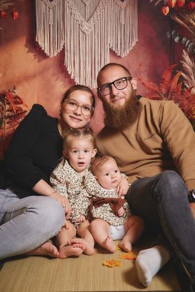 Parents assis avec leurs deux jeunes enfants devant un macramé d'automne, chez Tape à l'Œil à Nivelles
