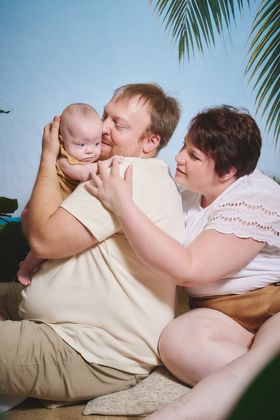 Parents qui serrent leur bébé dans leurs bras, décor de plage, chez Aubert à Vendin-le-Vieil