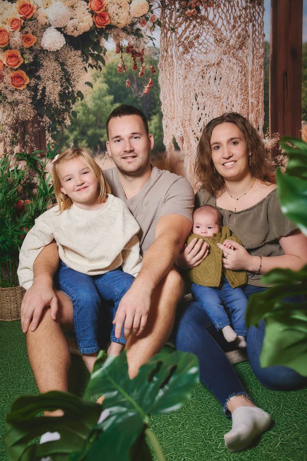 Parents avec leur fille et leur bébé, décor de prairie fleurie, chez Okaïdi à Mouscron