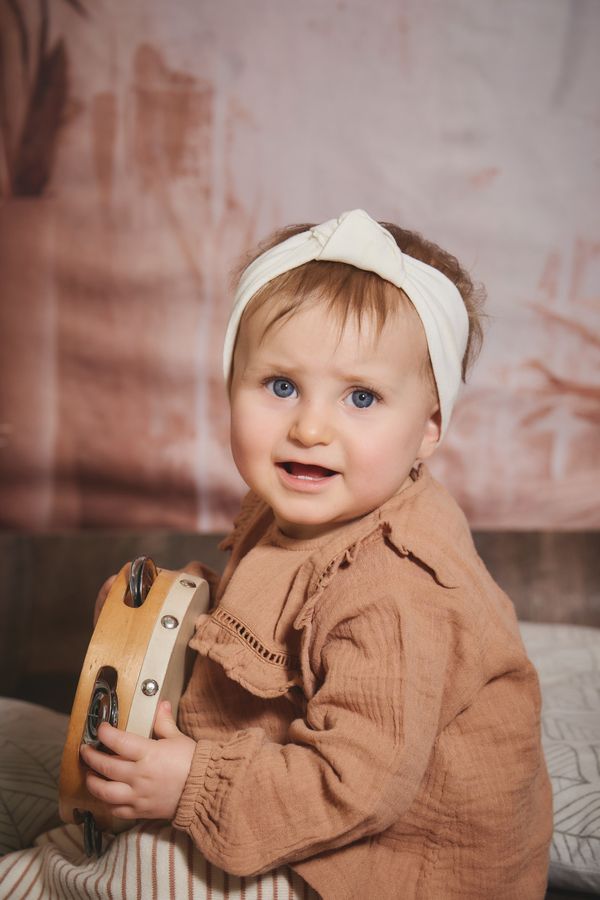 Bébé au bandeau blanc qui joue du tambourin, chez Aubert à Bailleul