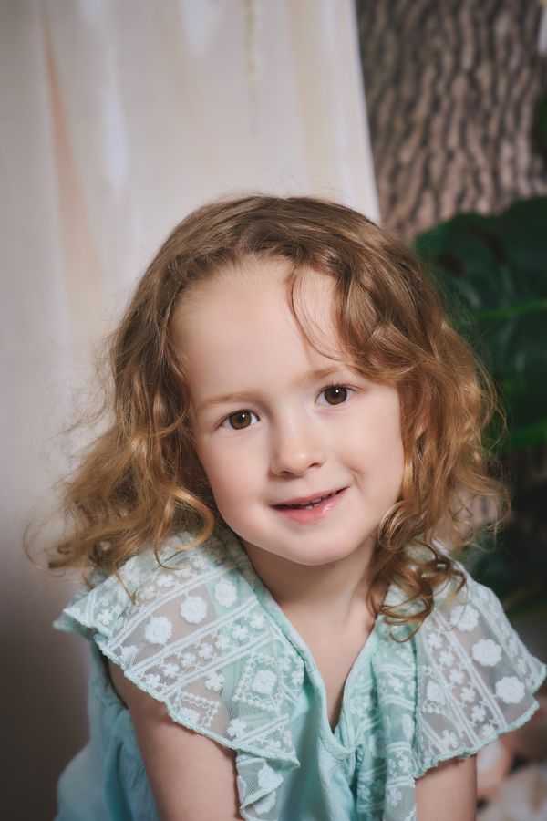 Portrait d'une petite fille aux cheveux bouclés, séance photo à domicile avec le studio mobile