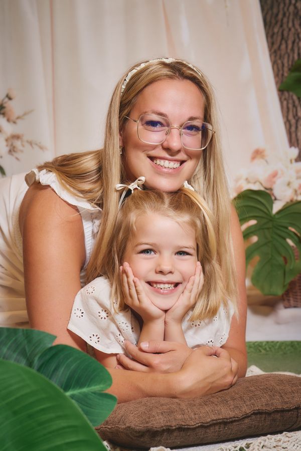 Maman et sa fille souriantes, joue contre joue, décor fleuri, chez Tape à l'Œil à Waterloo