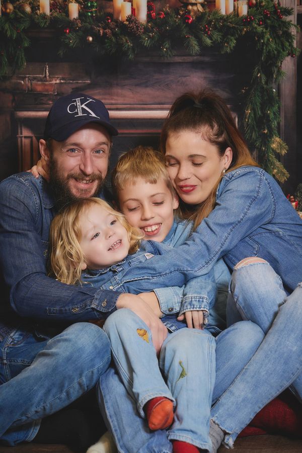 Famille de quatre blottie devant une cheminée de Noël, chez Aubert à Coudekerque
