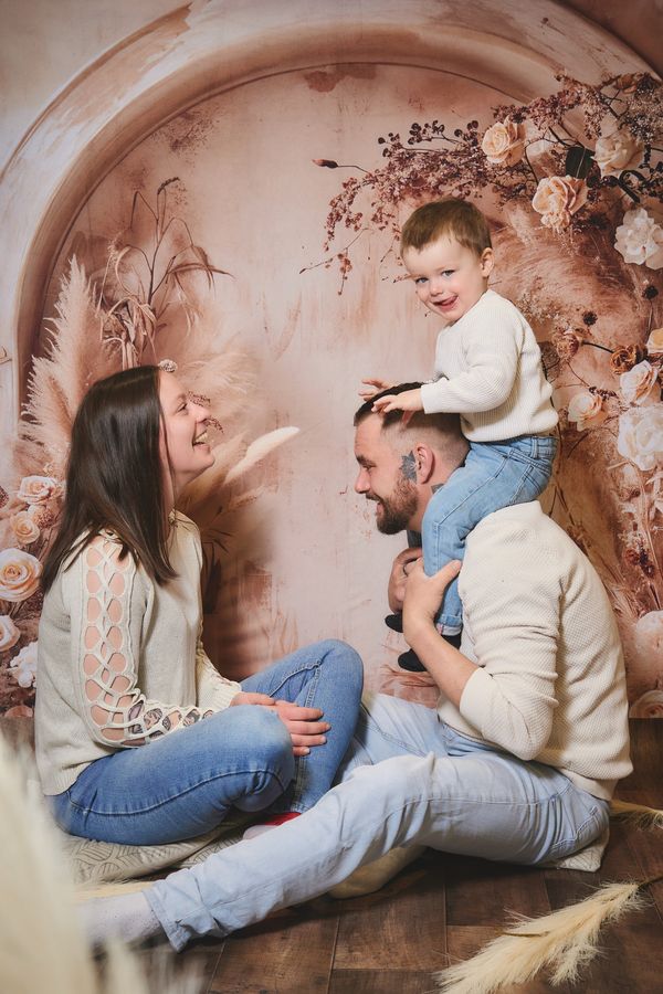 Parents qui jouent avec leur petit garçon devant un décor bohème d'herbes de la pampa, chez Aubert à Coudekerque